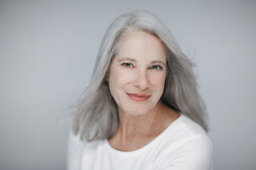 stunning beautiful and self confident best aged woman with grey hair smiling into camera