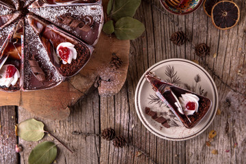 Chocolate cake with nuts, cut into slices on a rustic background. View from above. Free space for text.