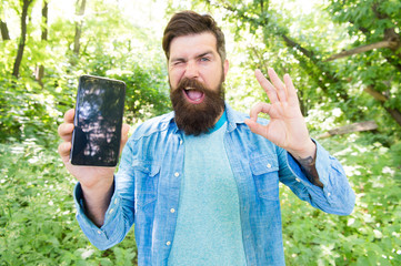 cool gadget. cheerful bearded man hold phone. Mature hipster beard with ok gesture. got lost in...