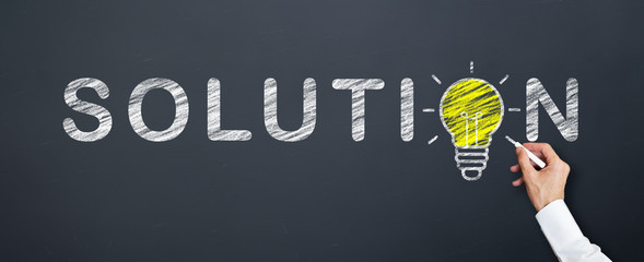 businessman is drawing yellow lamp into solution word on chalkboard