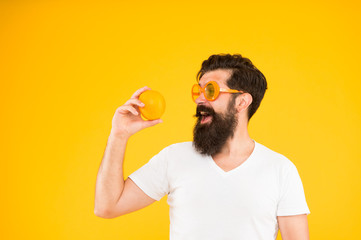 Best orange snack. Happy guy taking snack break on yellow background. Hipster looking at healthy organic snack. Snack that gives you energy, copy space