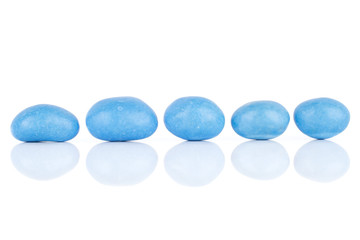 Group of five whole blue sugared nut dragee in line isolated on white background