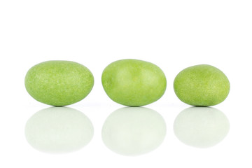 Group of three whole green sugared nut dragee isolated on white background