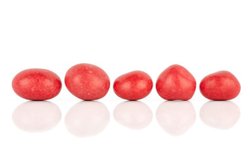 Group of five whole red sugared nut dragee isolated on white background