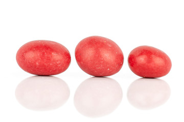 Group of three whole red sugared nut dragee isolated on white background