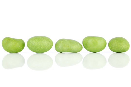 Group of five whole green sugared nut dragee isolated on white background