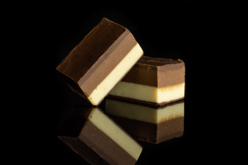 Group of two whole mellow two coloured nougat piece isolated on black glass