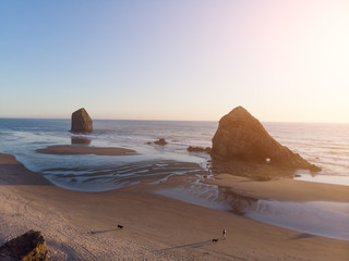 embankment of the ocean with sand and a road in the forest with a rock in the water, at sunset shot...