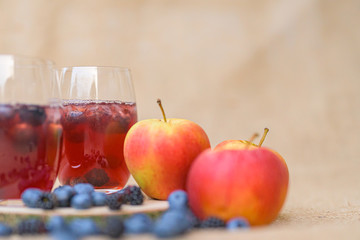 delicious red  berries Cocktail with blueberries in front of a blurred brown background
