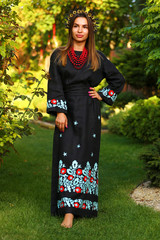 portrait of young woman in autumn park in national Ukrainian wear dark Embroidered shirt