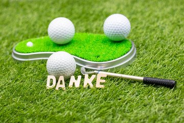 Golf german danke thank you with golf ball on green grass