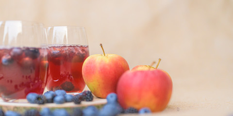 delicious red  berries Cocktail with blueberries in front of a blurred brown background