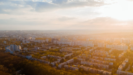 Shot of a beautiful city located at the edge of a forest, and a blue sky, during sunrise.