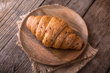Freshly baked croissants on wooden boards, with wheat eart. Free space for text.