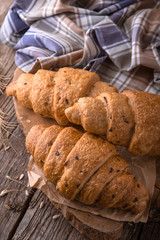 Freshly baked croissants on wooden boards, with wheat eart. Free space for text.