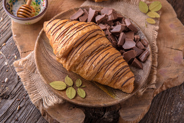Freshly baked croissants with chocolate and honey on wooden boards. Free space for text.