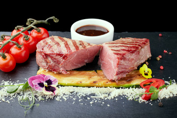 Meat steak with a sauce, on a black stone