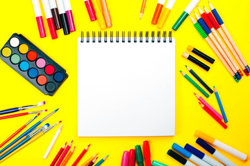 School supplies on yellow background and note book with copy space. Back to school concept.