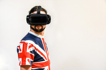 Man on white background with Virtual Reality headsets on, experimenting and testing new VR technology. Man with 4K Glasses watching games or videos.