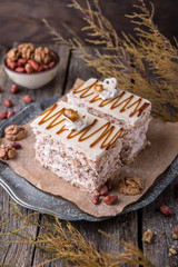 Sliced nut cake with honey and meringue. A piece of dessert on wooden boards.