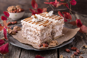Sliced nut cake with honey and meringue. A piece of dessert on wooden boards.