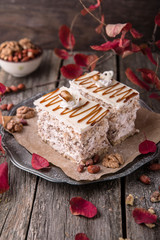 Sliced nut cake with honey and meringue. A piece of dessert on wooden boards.