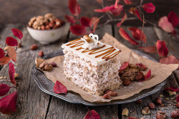 Sliced nut cake with honey and meringue. A piece of dessert on wooden boards.