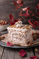 Sliced nut cake with honey and meringue. A piece of dessert on wooden boards.