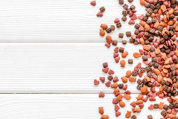 Dog dry food on white wooden background top view copyspace