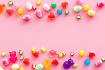 Assorted sweets and marmalade frame on pink background top view space for text