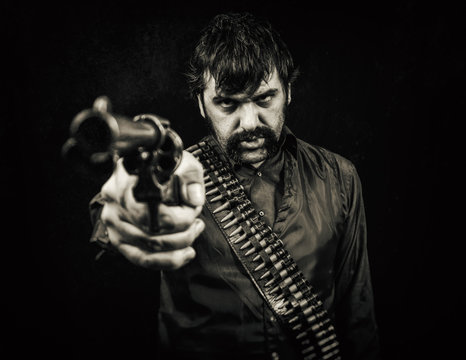 Old west cowboy outlaw with a bandolier of bullets and a revolver pistol handgun.