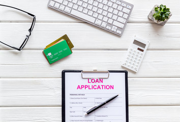 loan application with bank cards and keyboard on white wooden background top view