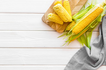 Ripe corn on cobs on white wooden table background top view mock up