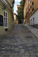 Narrow cobblestone street with colorful buildngs in Prague