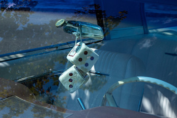 Dices hanging on the mirror of an automobile