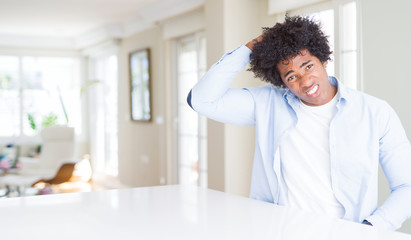 African American man at home confuse and wonder about question. Uncertain with doubt, thinking with...