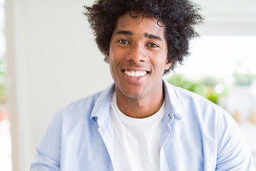 Handsome african american man with afro hair with a happy and cool smile on face. Lucky person.