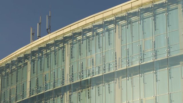 Glass Curtain Facade Wall Tilt Up on Roof Cellular Antennas. Fasteners Elements of Spider Glass System. Facade Detail. Architecture Abstract Background.