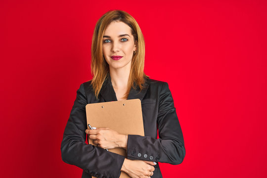 Young beautiful redhead businesswoman wearing suit holding flip board