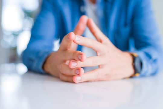 Close up of man hands with palms together over white table