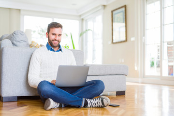 Handsome man wearing working using computer laptop with a happy face standing and smiling with a confident smile showing teeth