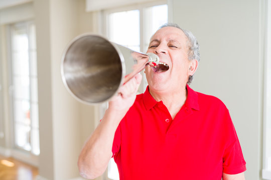 Senior man shouthing excited through vintage metal megaphone