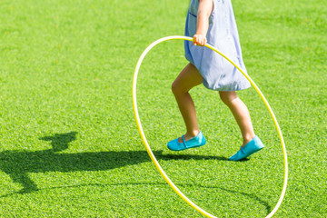 Little girl running with hula hoop