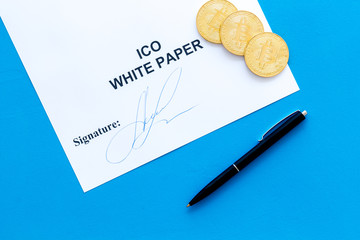 Initial coin offering ICO white paper, bitcoin, pen on blue background top view