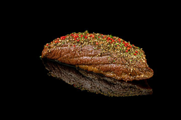 baked beef tenderloin on black glass with reflection