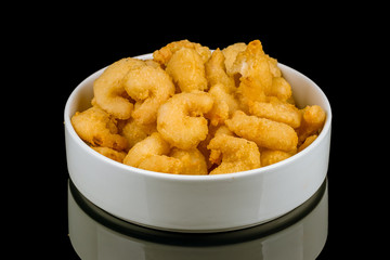 Prawns in batter on black glass with reflection