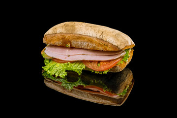 ciabatta with ham on black glass with reflection
