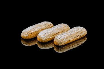 vanilla eclairs on black glass with reflection