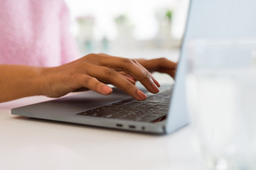 Close up of young woman working typing using laptop