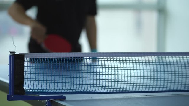 Ping pong table, Male playing table tennis with racket and ball in a sport hall